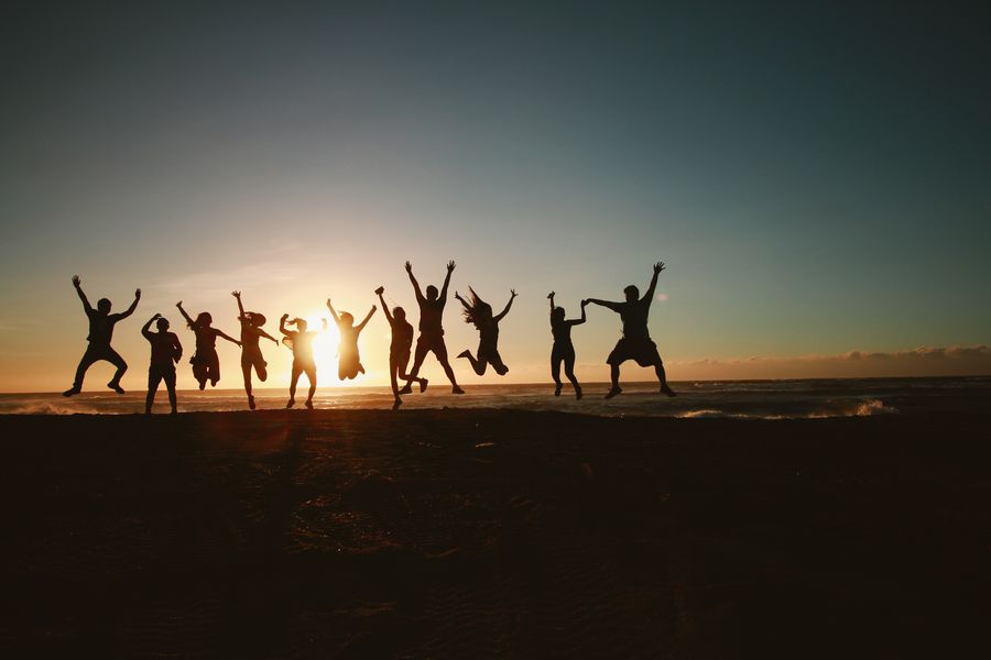 silhouette photography of group of people jumping during golden time — Developers · Nigeria: The connected trip: maps, messages and translation, all on one eSIM.