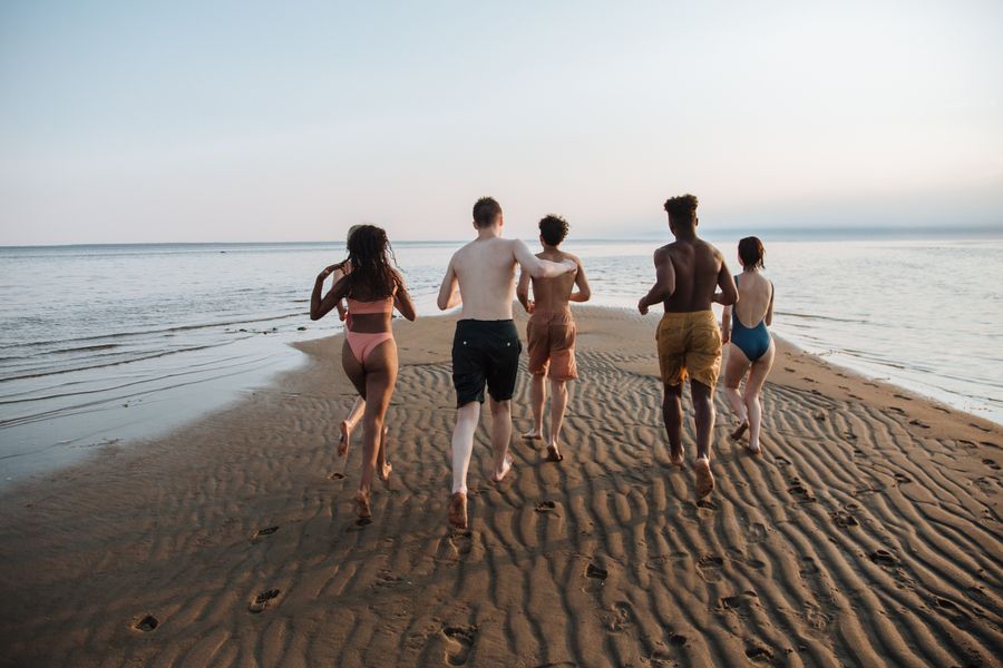 teenagers running towards sea