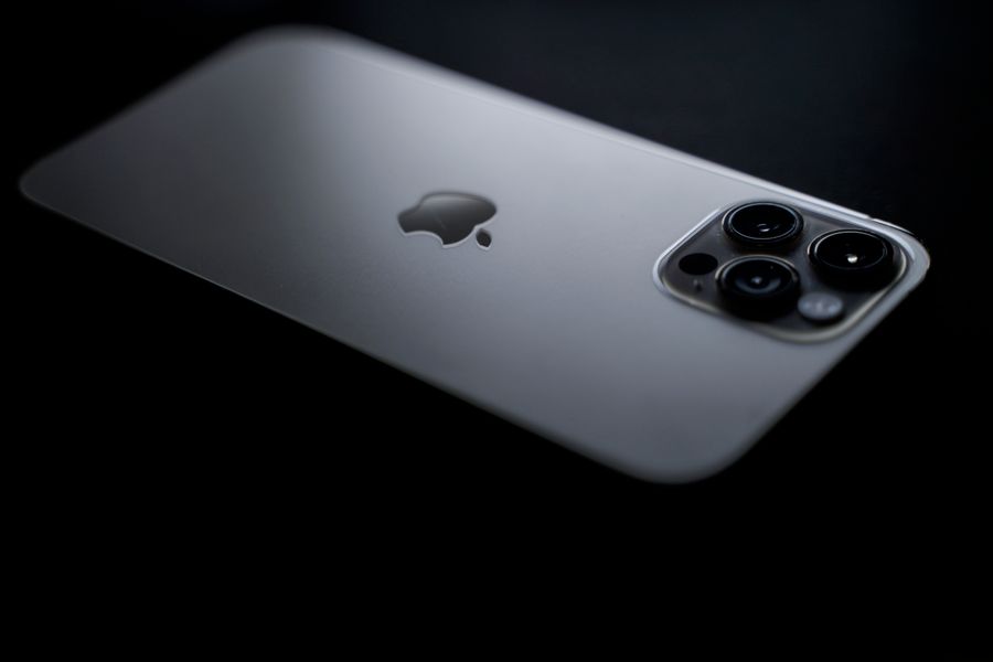silver iphone on black surface