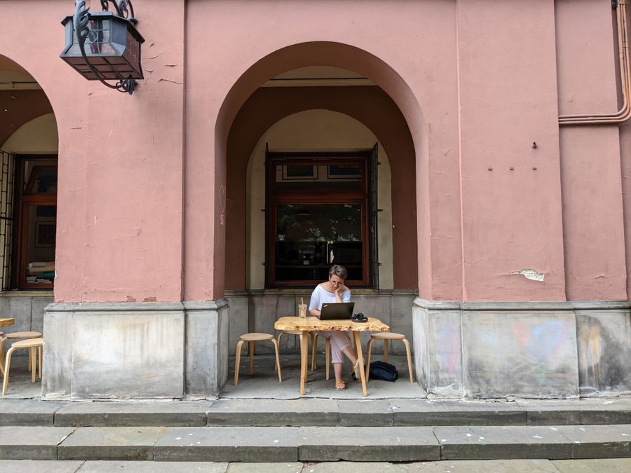 a woman using a laptop while sitting on a chair — Developers · Finland: Museum afternoons with audio guides streaming, not buffering.