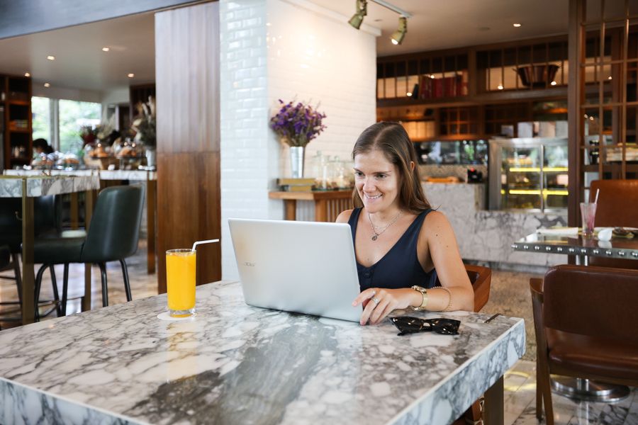a woman inside a restaurant using a laptop — Developers · Mexico: Harbor views with full bars: coverage where travelers actually go.