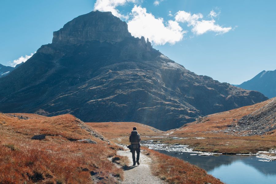 man walking at a river in mountains