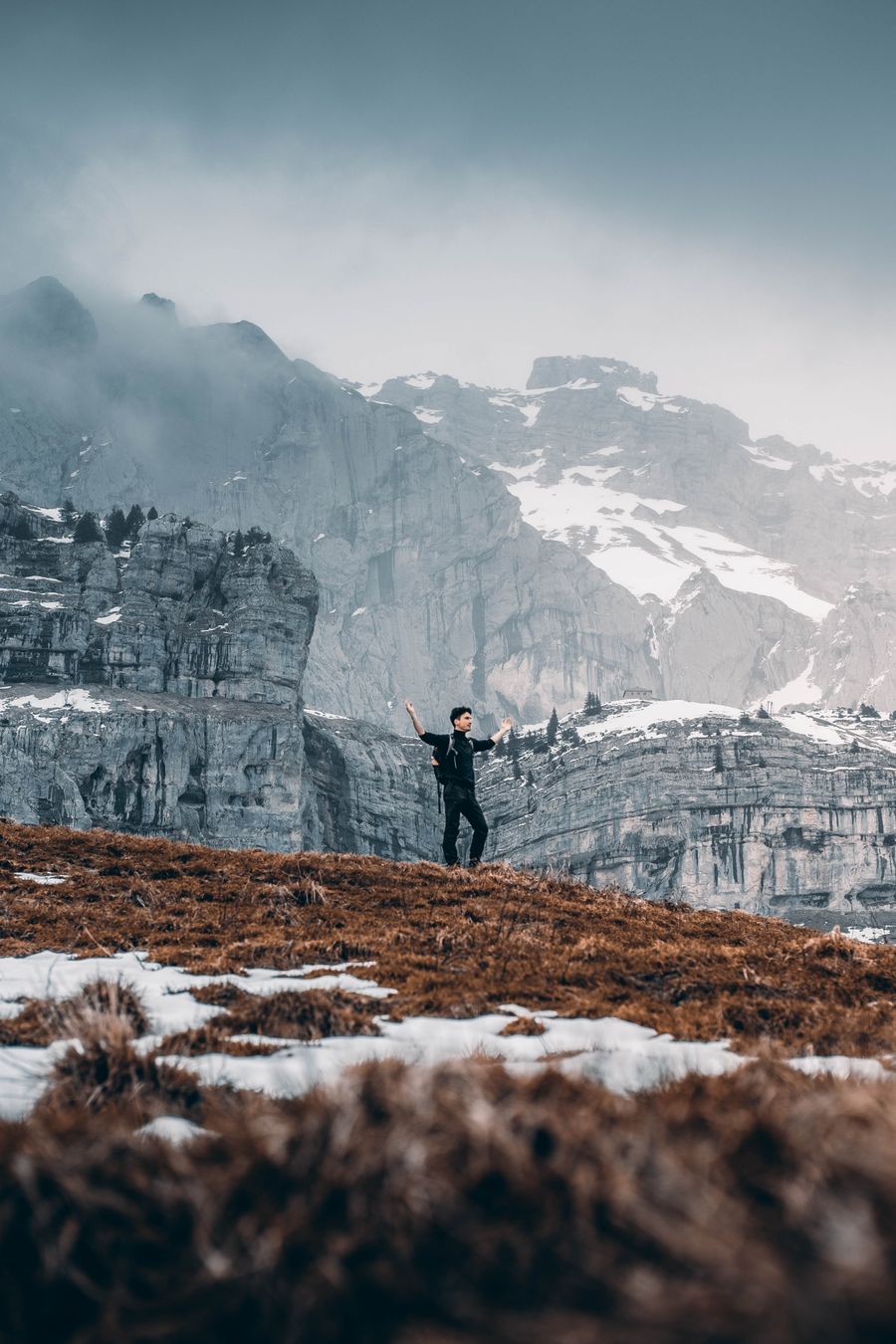 hiker in mountains raising hands