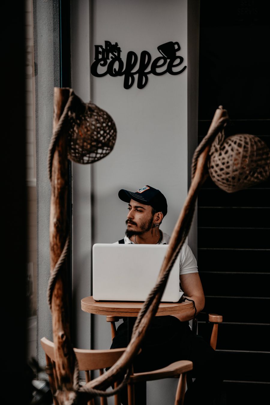 man in cap sitting by table with laptop — Developers · Bosnia and Herzegovina: The viewpoint at golden hour: livestream the sunset to everyone back home.