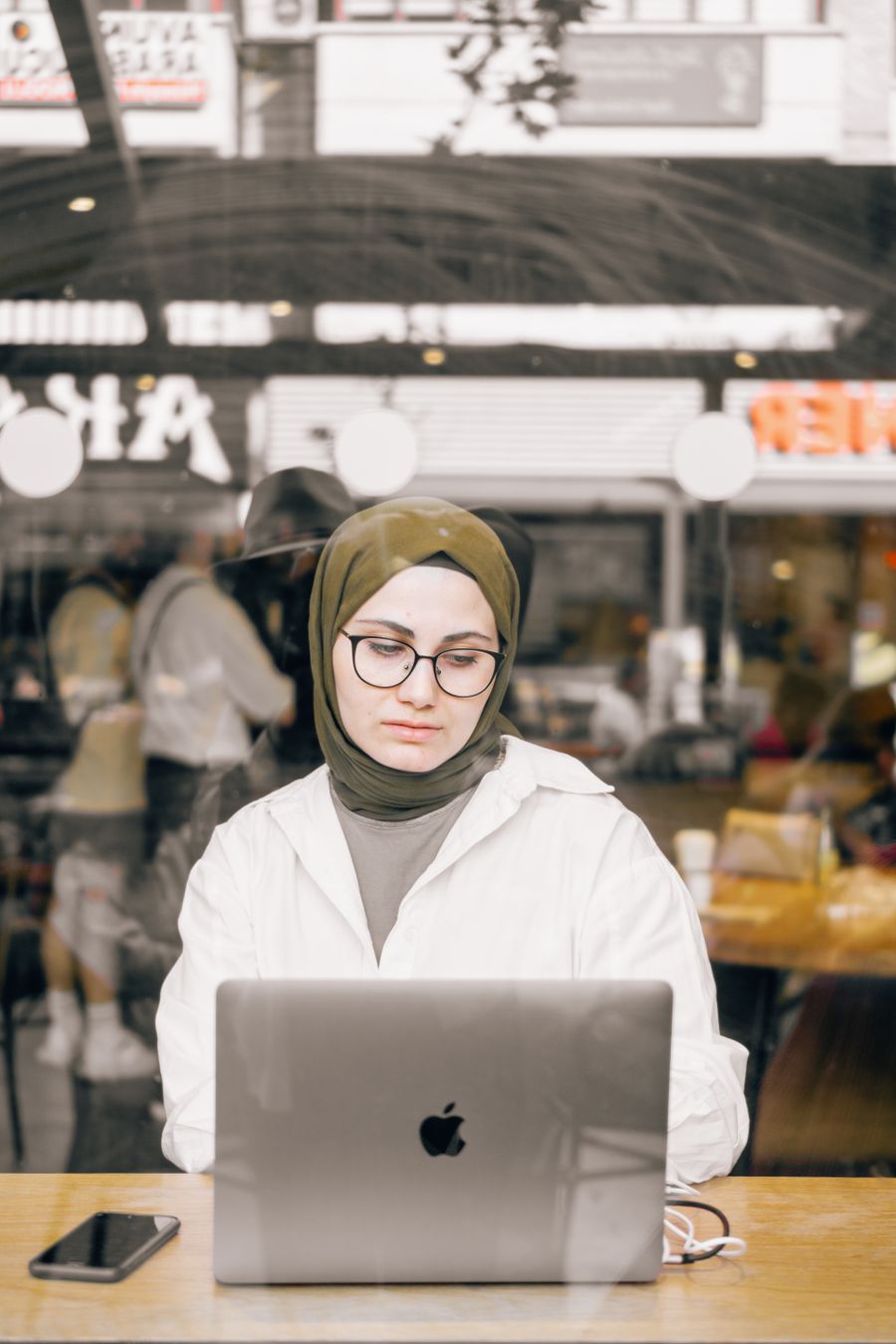 woman using a laptop in a restaurant — Support: The window seat office: emails sent somewhere over the ocean.