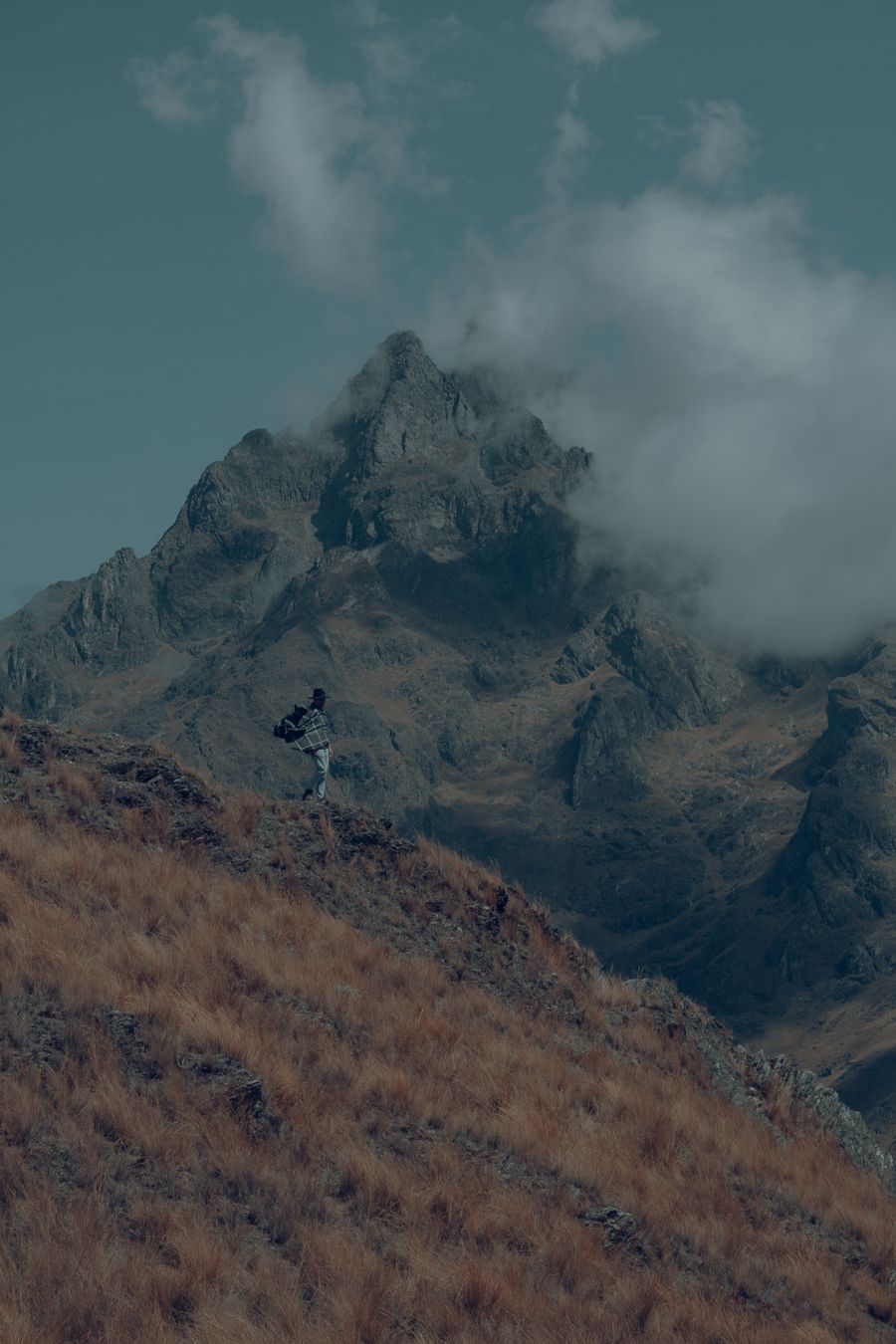 man with a backpack standing on a mountain slope — Developers · Timor-Leste: Downtown, connected: the eSIM finds the fastest local network on its own.