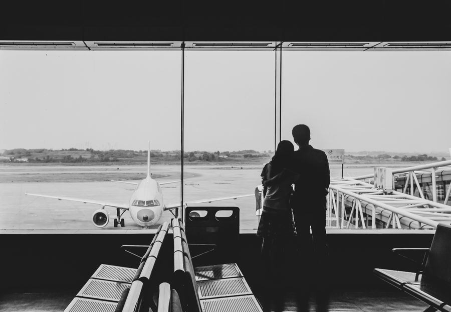 back view of couple embracing at airport