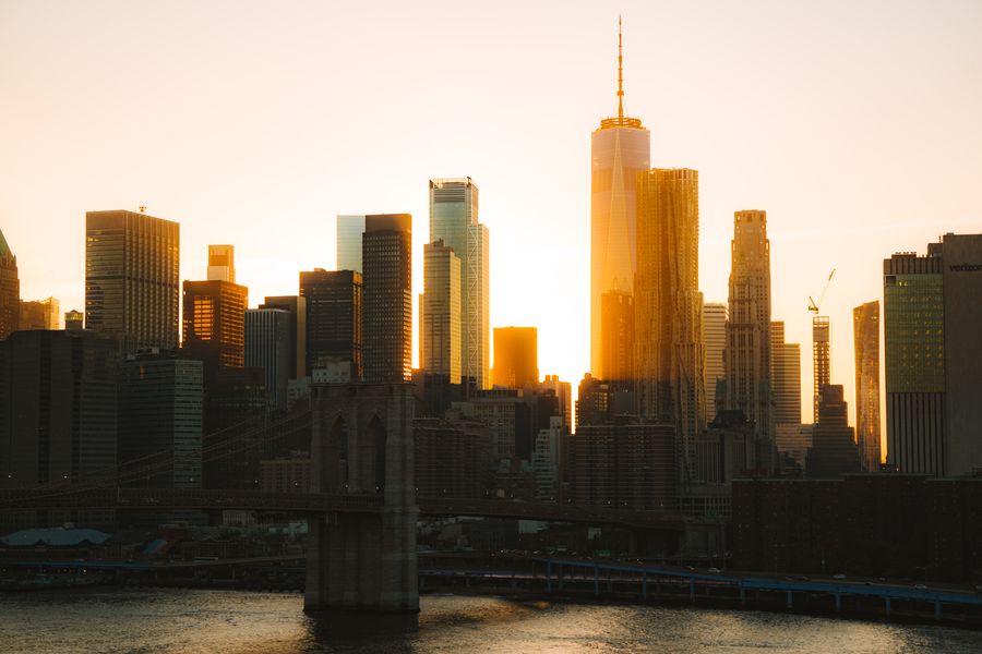 rising sun behind nyc downtown