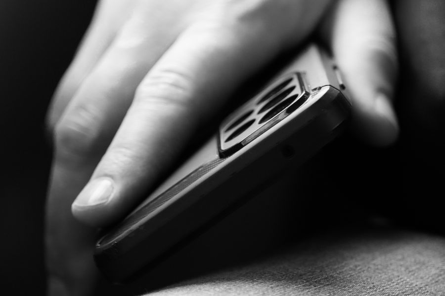 man holding mobile phone in black and white — Terms: Check-in lines move faster when your documents are on your phone.