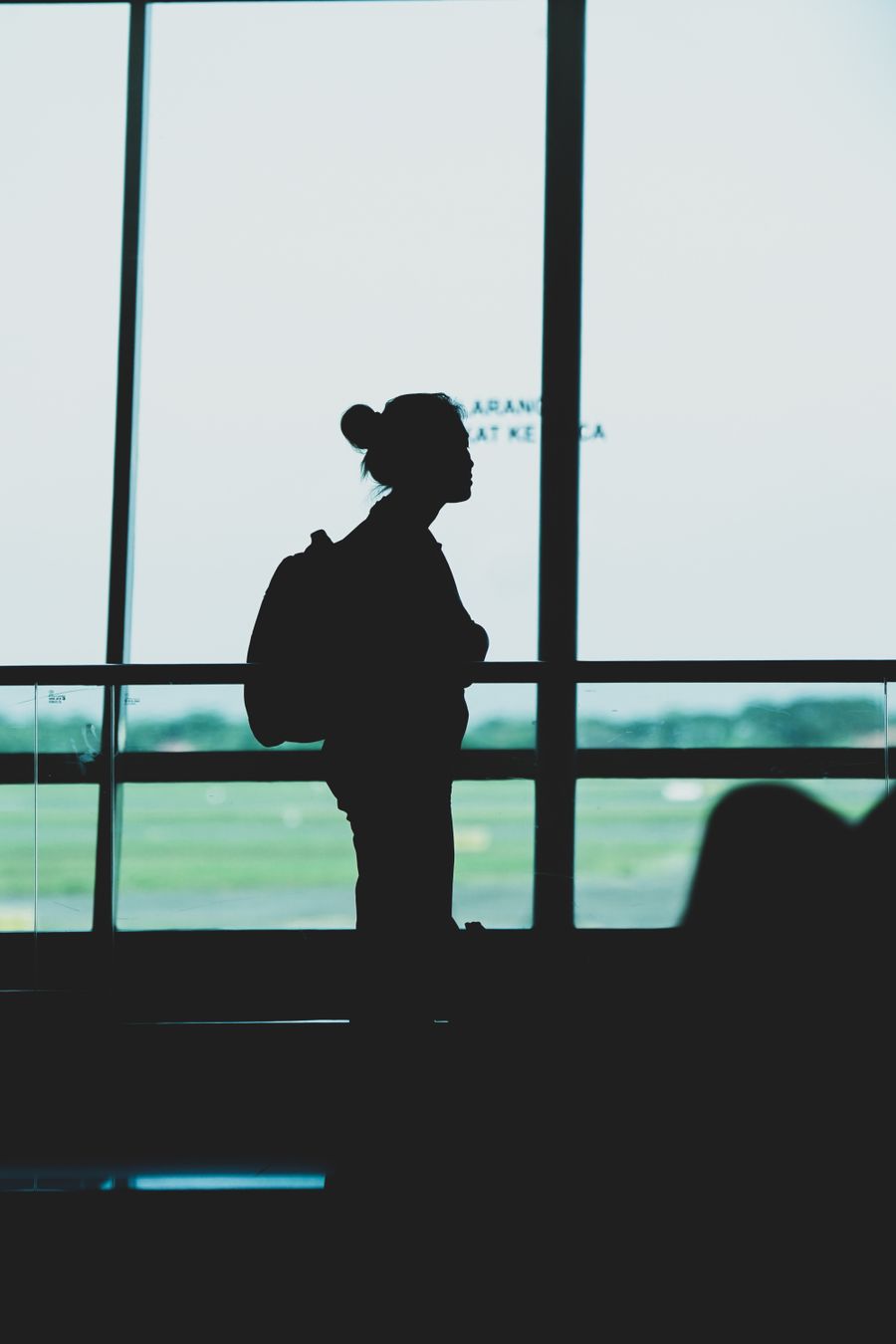 silhouette of a woman with a backpack standing at an airport terminal — Developers · Paraguay: The red-eye recovery: hotel early-check-in arranged mid-flight.