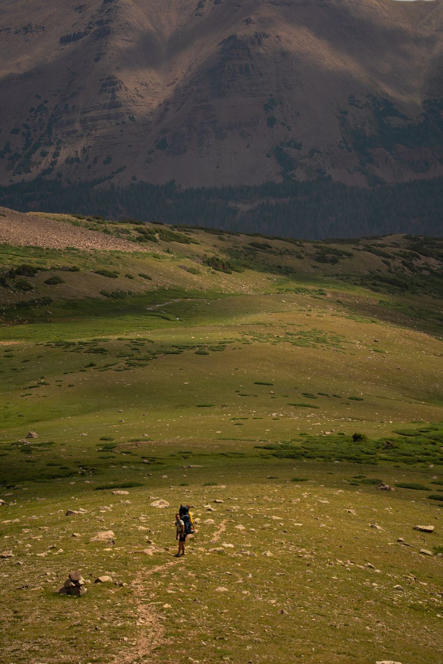 a person walking on a trail in the mountains — Docs: Plazas and promenades: video calls home with the view behind you.