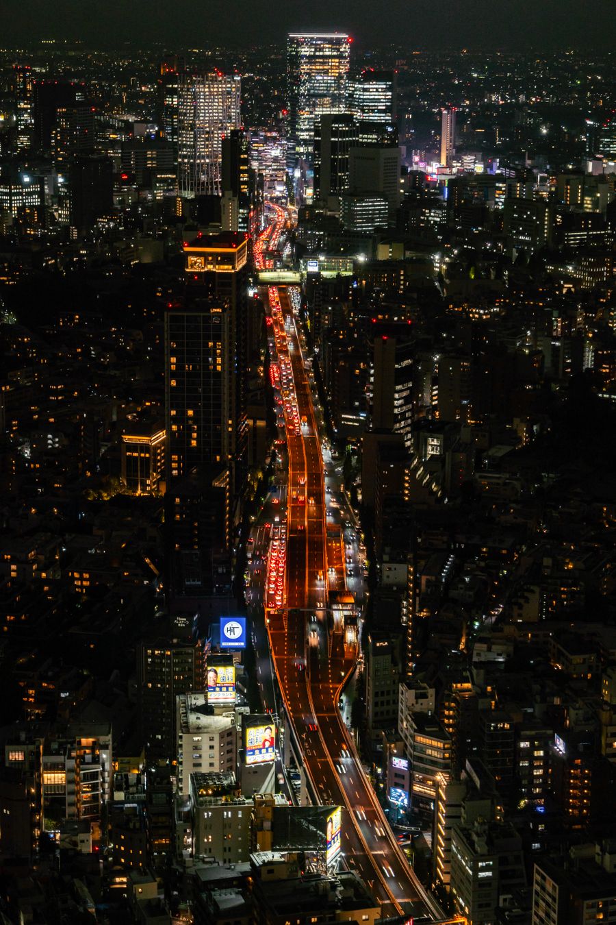 tokyo night cityscape with busy traffic — Support: The night bus: entertainment downloaded, messages queued, rest easy.