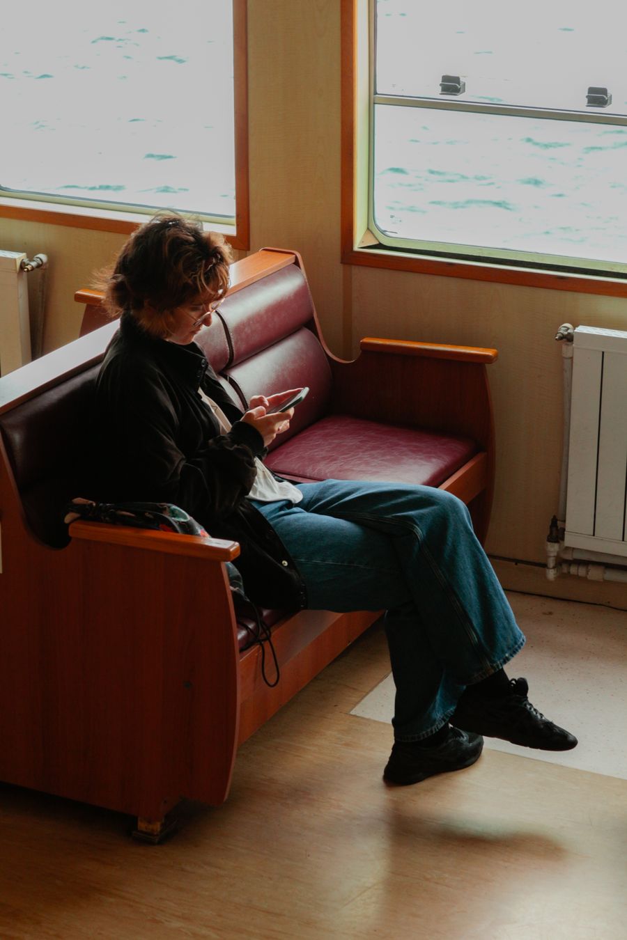 A woman sitting comfortably on a ferry, enjoying a peaceful journey. — Developers: Border crossings without the paperwork shuffle: ID photos stored on the phone.