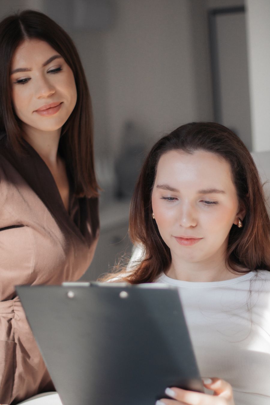 two women collaborating on a project indoors — Developers · Indonesia: The welcome home: eSIM deleted in one tap, no contract to cancel.