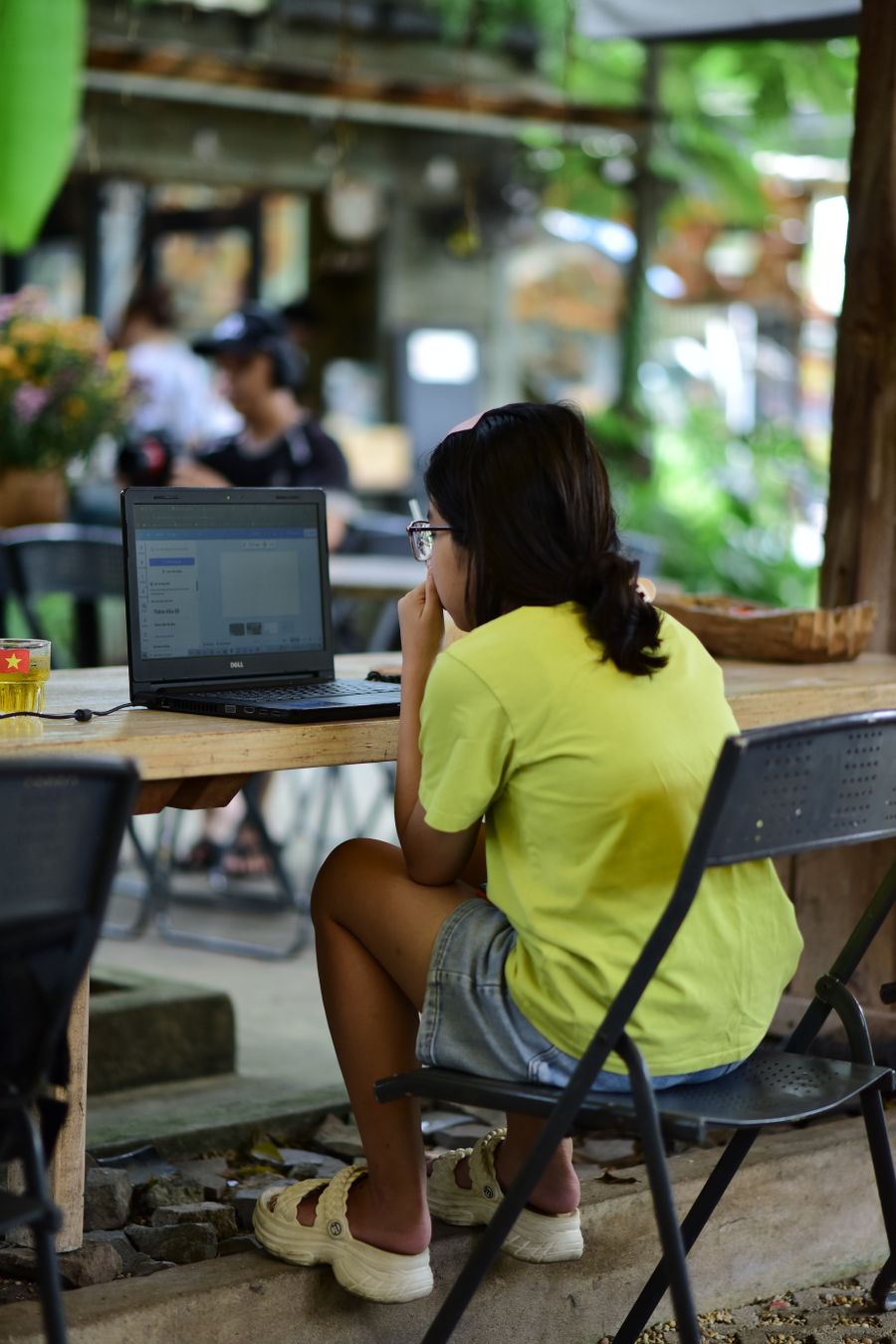 woman working on laptop in outdoor cafe setting — Developers · the Philippines: SDKs, a CLI, and an MCP server — the developer surface, complete.