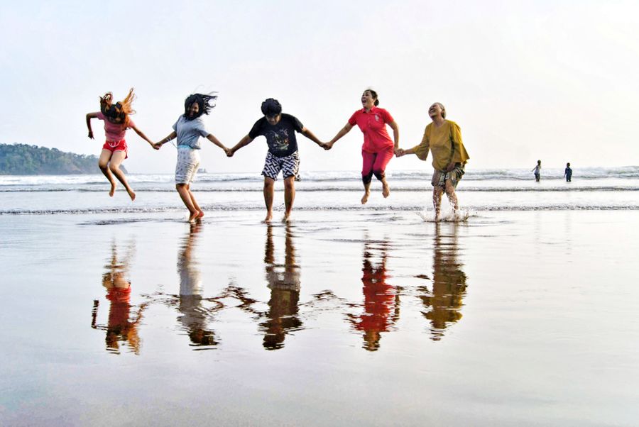 friends jumping at pangandaran beach — Support: Island time, online time: ferries, beaches and full signal.