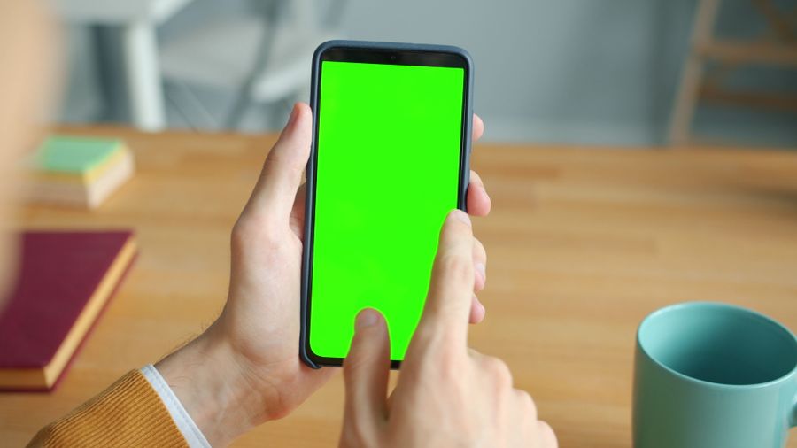 person using smartphone with green screen at desk — Developers · Libya: Sandbox first: test provisioning without spending a cent.