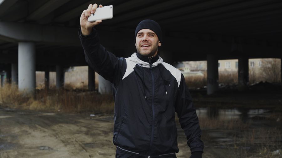 Man in sportswear taking a selfie under a bridge, capturing an urban moment. — Developers · Moldova: Family group chat: location shared, dinner plans settled in minutes.