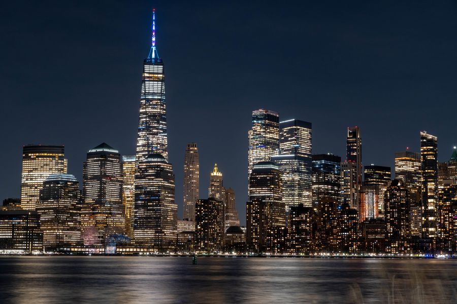 stunning nighttime view of new york city skyline — Developers · DR Congo: The business trip: client deck synced, video call joined from the taxi.