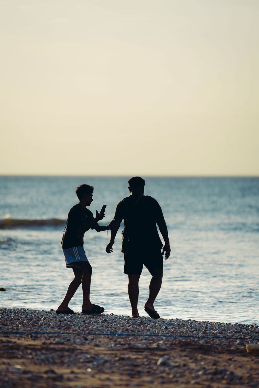 silhouette of two friends enjoying a beach sunset — Developers · Madagascar: Rainy-day backup plan: indoor attractions researched from the hostel bunk.