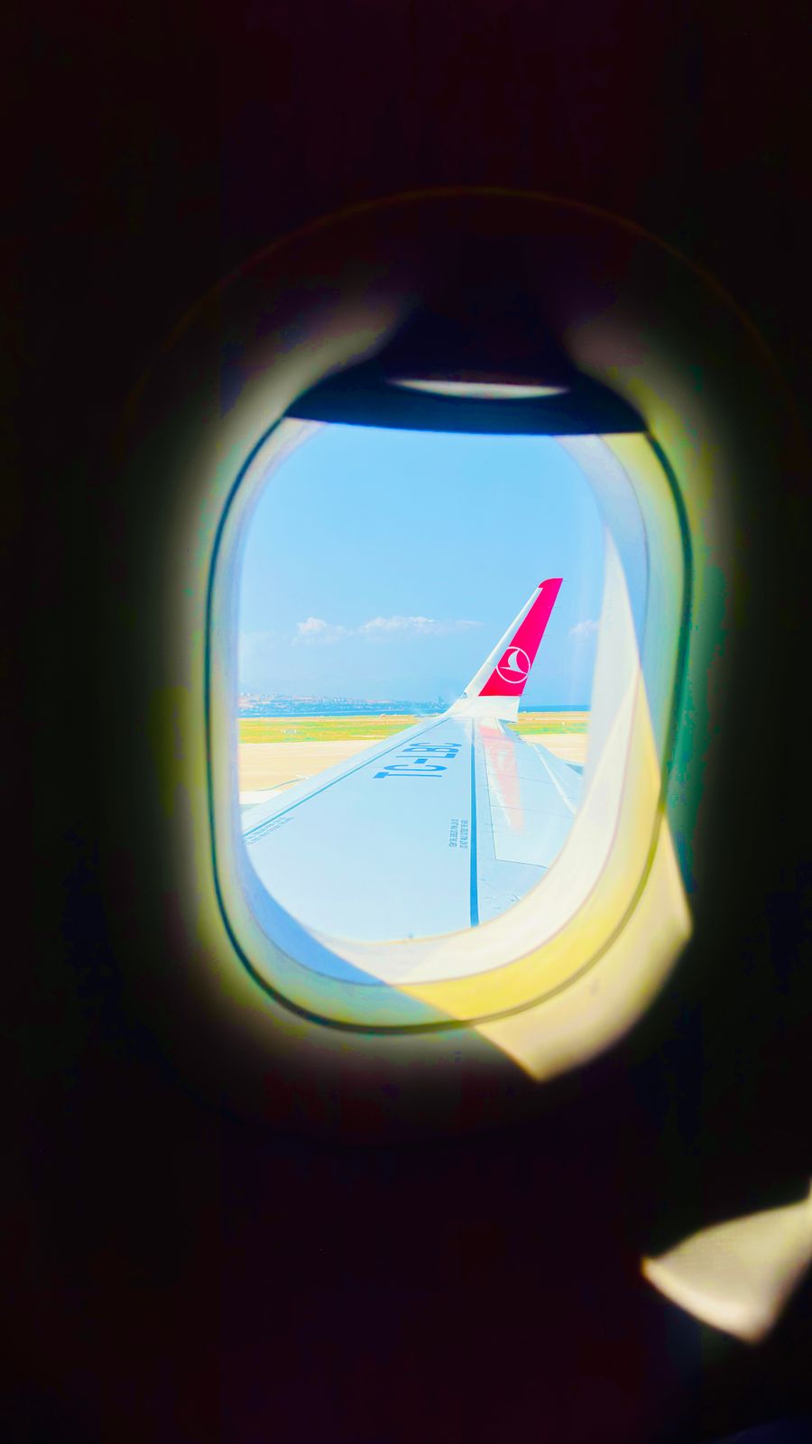 view from airplane window over turquoise skies