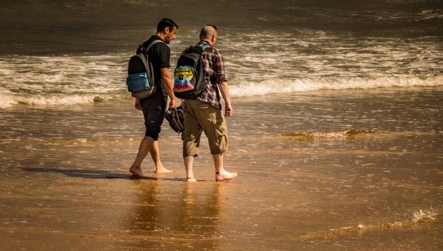 men with backpacks walking on the beach — Developers · Barbados: Currency exchange, skipped: the phone pays at the real rate.