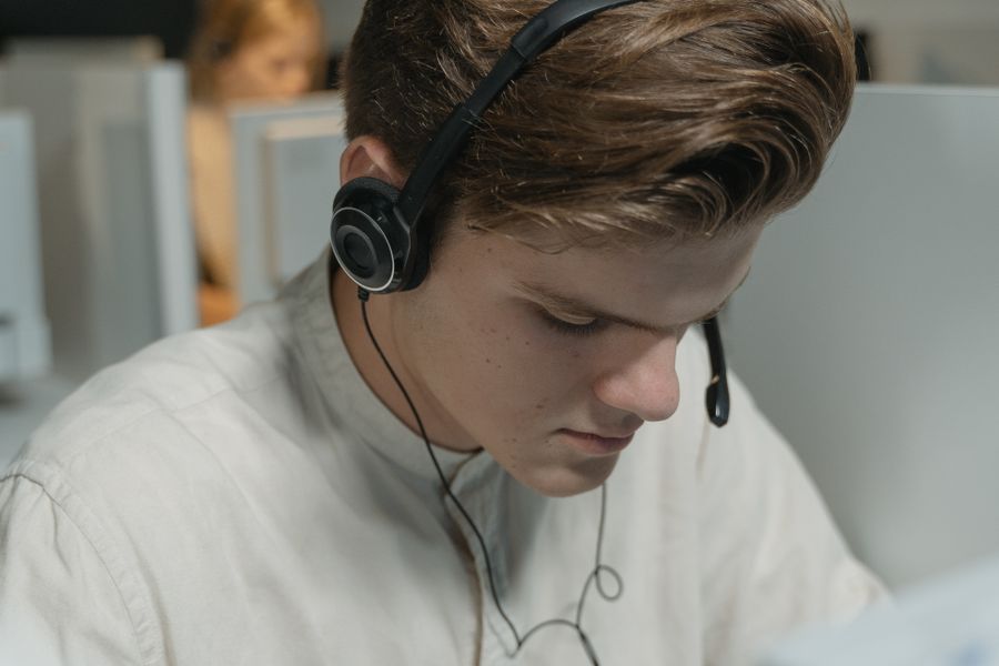a man in white crew neck shirt wearing black headphones — Developers · Malta: The group chat stays live across every border you cross.
