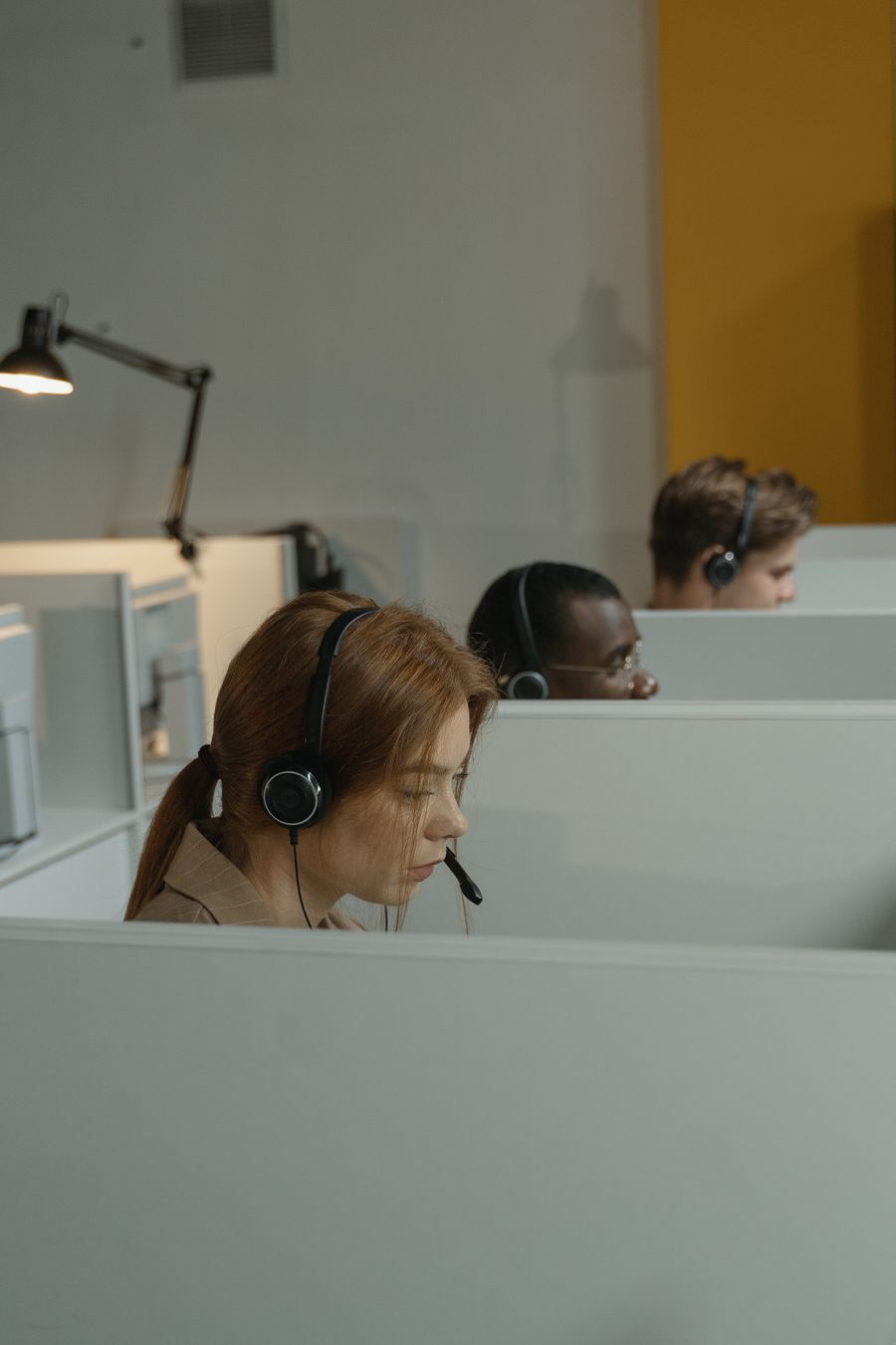 a woman with headset inside a gray cubicle — Developers · Cambodia: Currency exchange, skipped: the phone pays at the real rate.