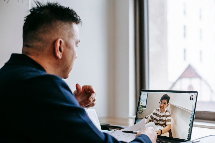photo of men talking through laptop — Developers · Saudi Arabia: The rental desk handshake: confirmation email open, license photo ready.