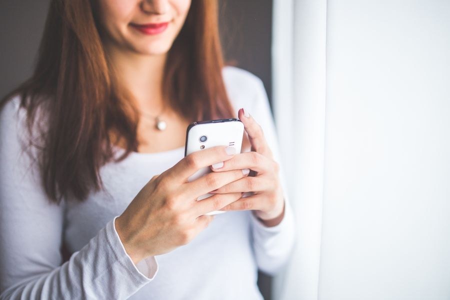 close up portrait of a young woman typing a text message on mobile phone — Developers · Azerbaijan: The conference badge: QR ticket scanned, session schedule synced.