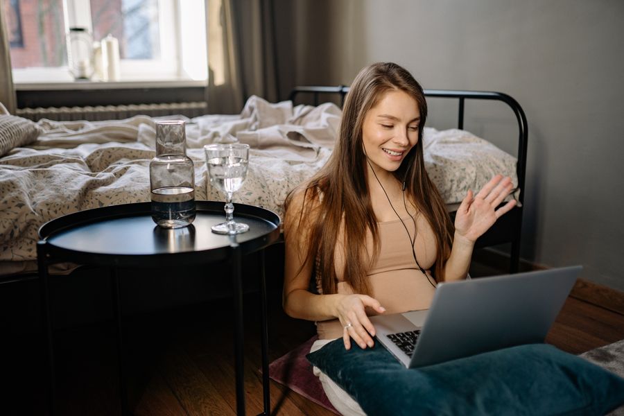 a woman waving her hand while looking at the screen of the laptop — Developers · Brazil: The departure board flips: gate found, lounge located, all on the eSIM.