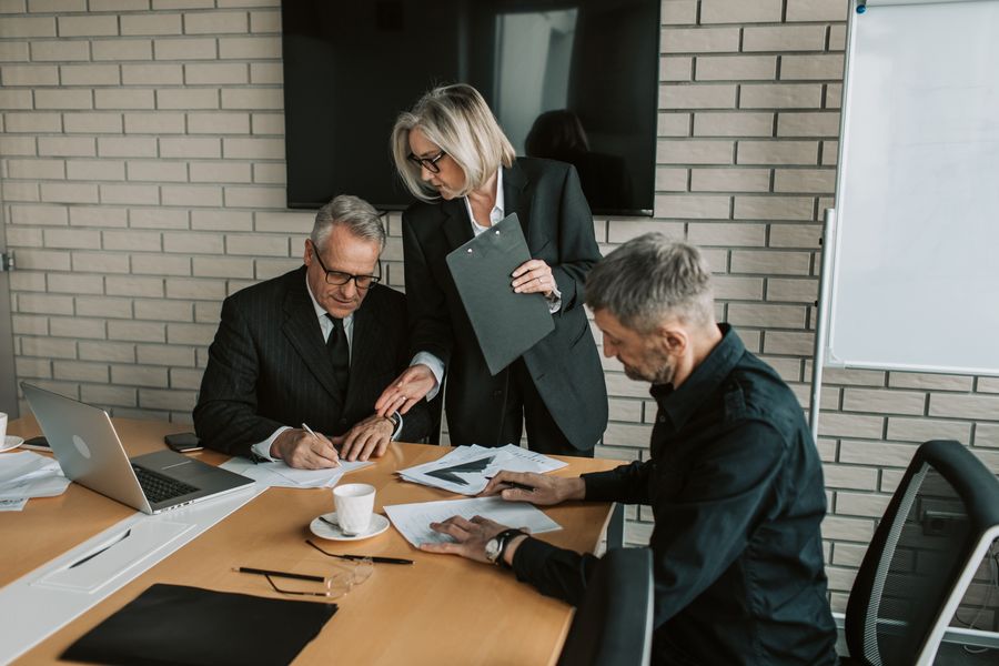 gray haired man signing the papers