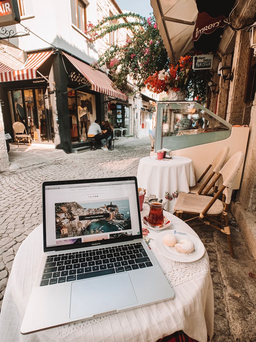 laptop standing on a table outside of a cafe with view of an alley — Developers · Libya: Street level: navigation, rideshares and reviews, all instant.