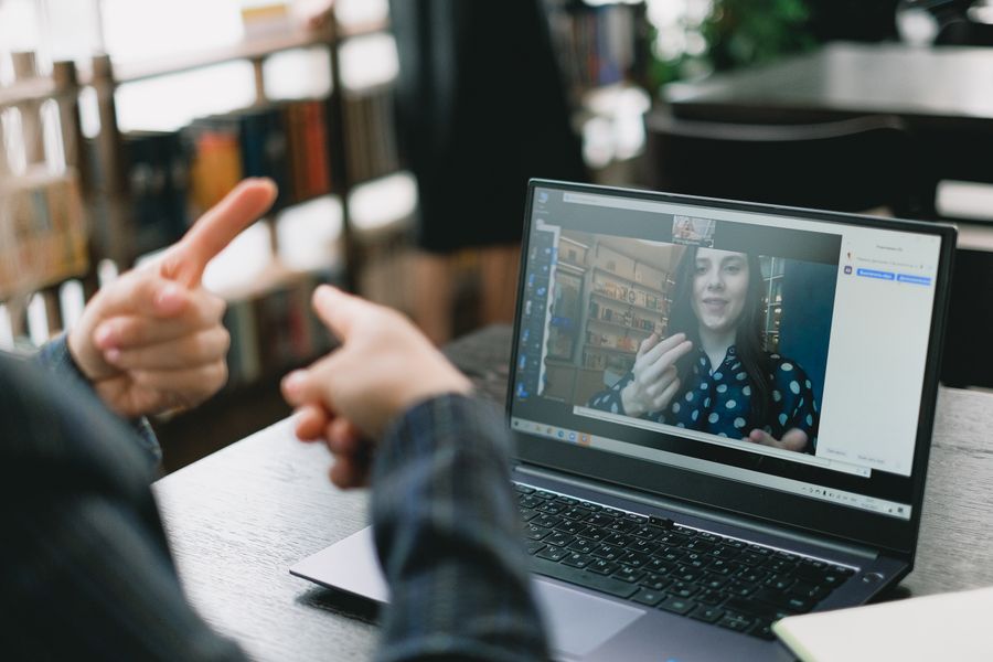 young lady learning sign language during online lesson with female tutor — Developers · Lesotho: The red-eye recovery: hotel early-check-in arranged mid-flight.