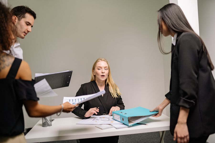 a woman in black blazer sitting at the desk with documents — Developers · Papua New Guinea: Plazas and promenades: video calls home with the view behind you.