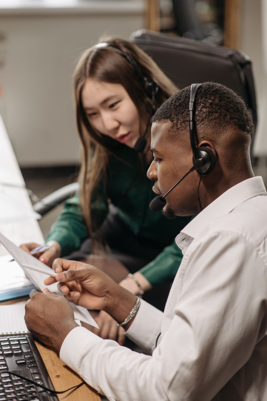 a man and woman having conversation while wearing headsets — Support: Platform to platform: tickets, timetables and taxis in one hand.