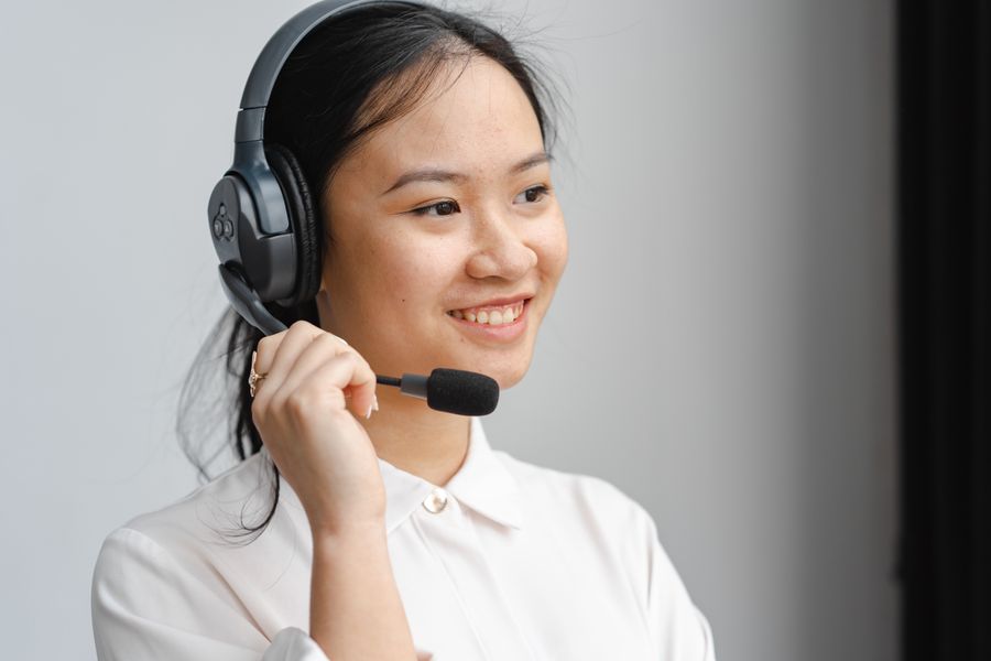 close up photo of a woman holding the microphone of her black headset — Developers · Norway: Border crossings without the paperwork shuffle: ID photos stored on the phone.