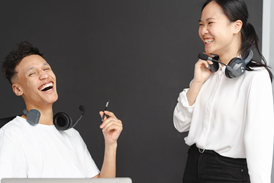 laughing man and woman working in a call center