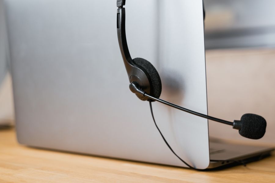 close up shot of headphones hanging on a laptop — Developers · Estonia: Hiking the ridge: trail map offline, emergency numbers saved.
