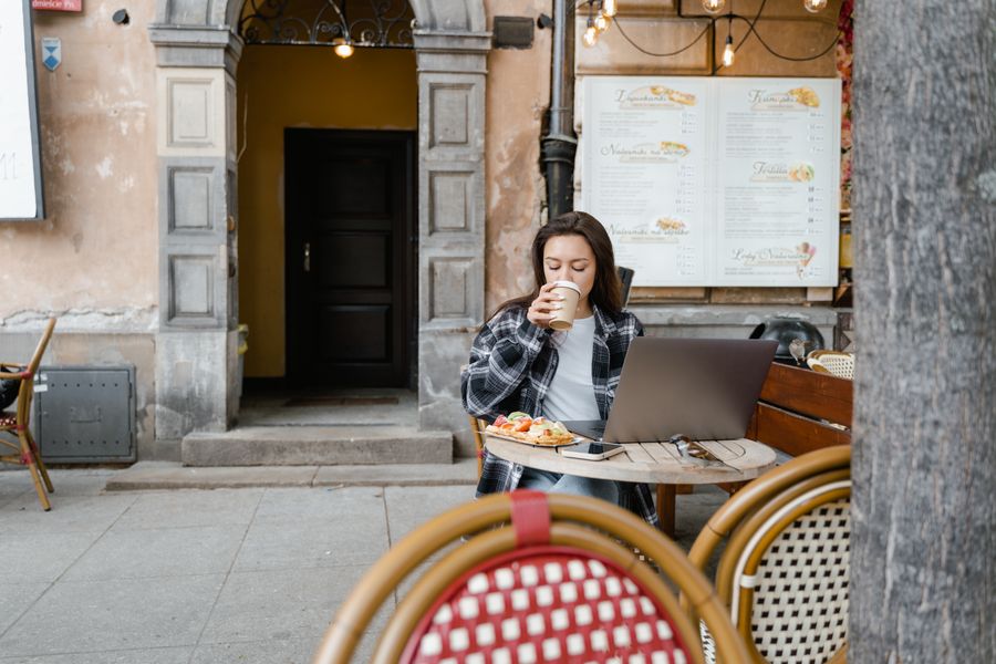 brunette woman drinking a cup of coffee — Developers · Andorra: The red-eye recovery: hotel early-check-in arranged mid-flight.