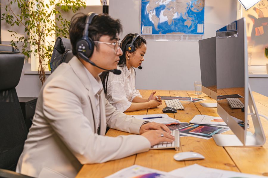 man and woman wearing a headset with a microphone in an office