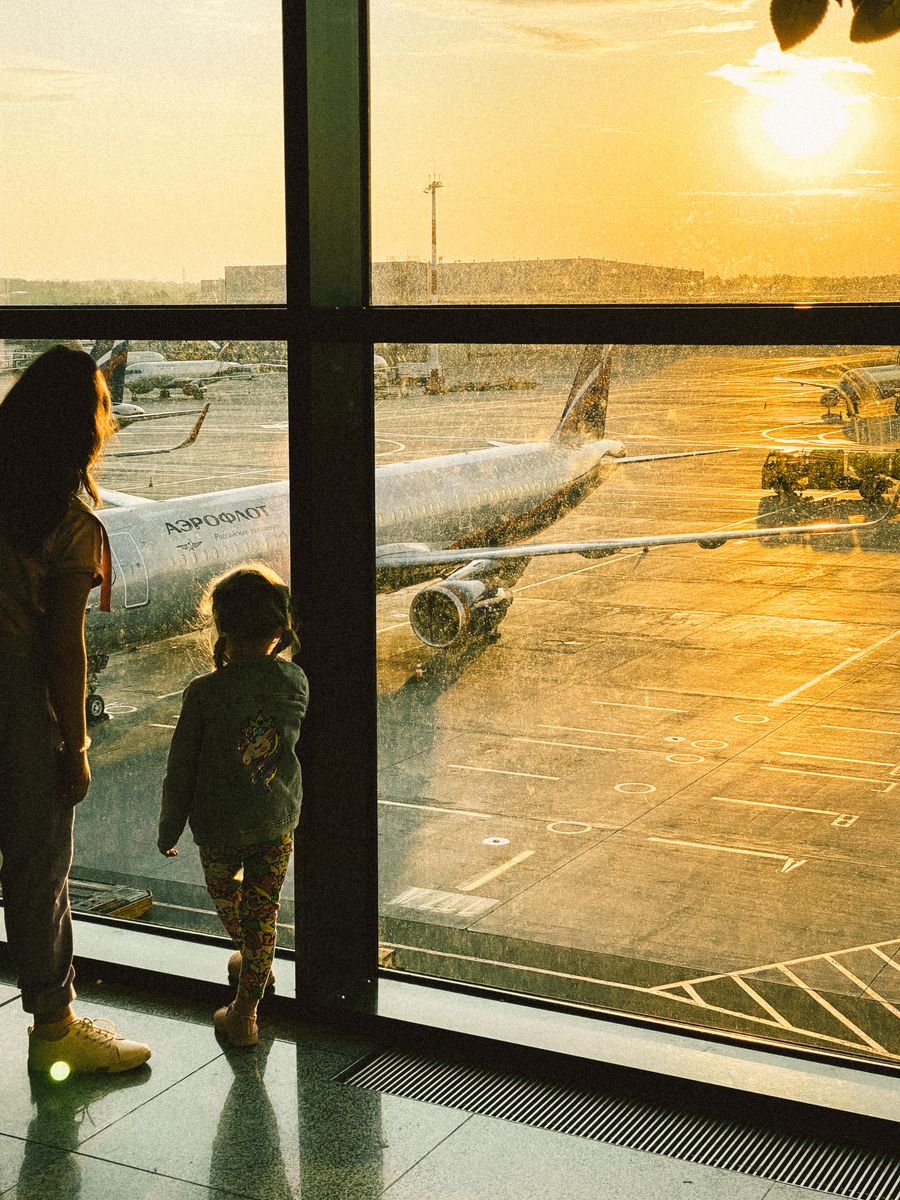 mother and daughter watching planes at an airport — Developers · Somalia: The viewpoint at golden hour: livestream the sunset to everyone back home.