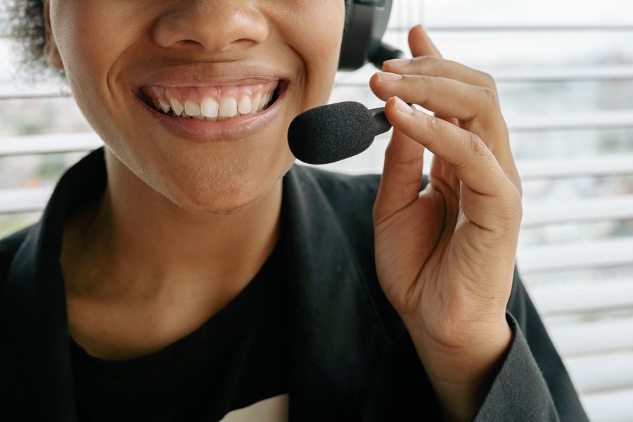 close up photo of a smiling woman holding microphone — Developers: Family group chat: location shared, dinner plans settled in minutes.