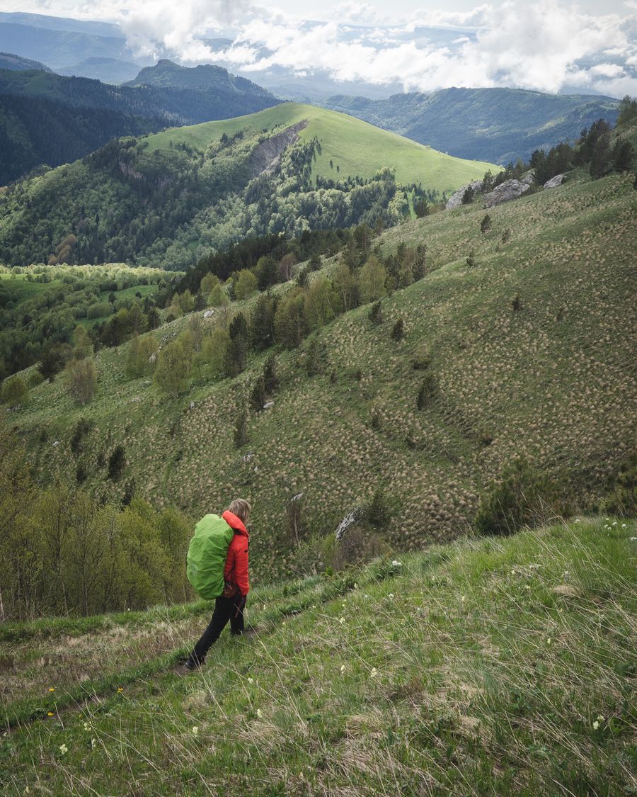 tourist hiking in grassy mountains